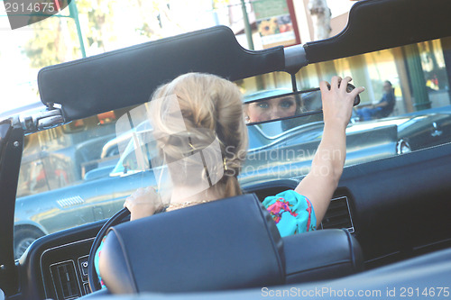 Image of Lovely Woman Posing and and Around a Vintage Car
