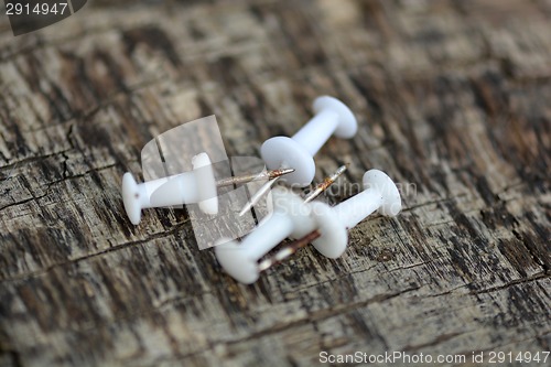 Image of Set of old white pins on wood background