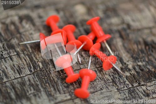 Image of Set of old red pins on wood background