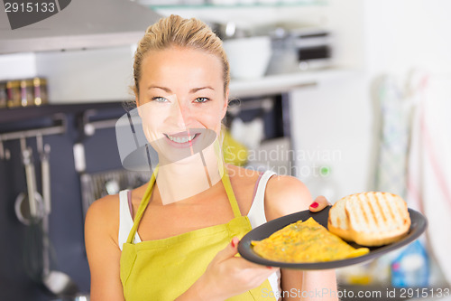 Image of Young Mother Cooking at Home.