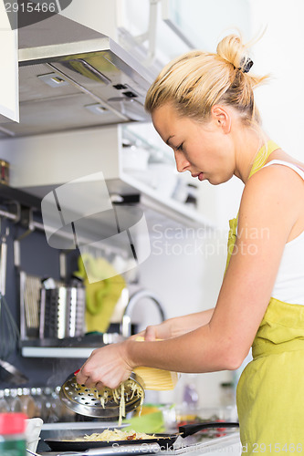 Image of Young Mother Cooking at Home.