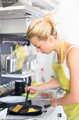 Image of Young Mother Cooking at Home.