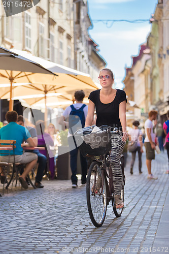 Image of Woman riding bicycle in city center.