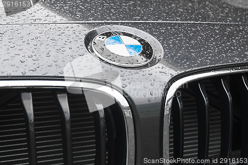 Image of BMW logo on wet surface of car hood