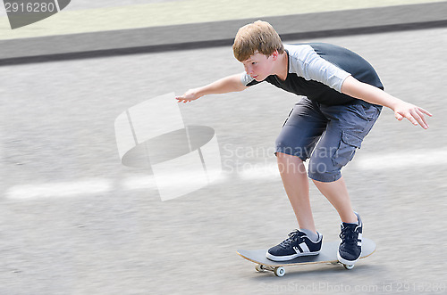 Image of Young skater teenager guy in motion moving on skateboard