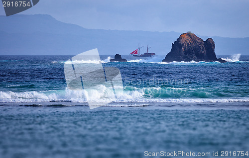 Image of Old two-masted schooner near the rocks in the sea. Indonesia, Ba