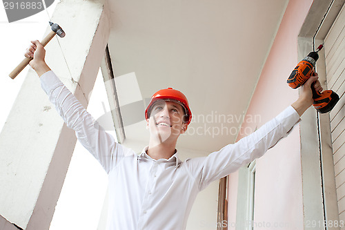 Image of engineer with a tools in raised hands