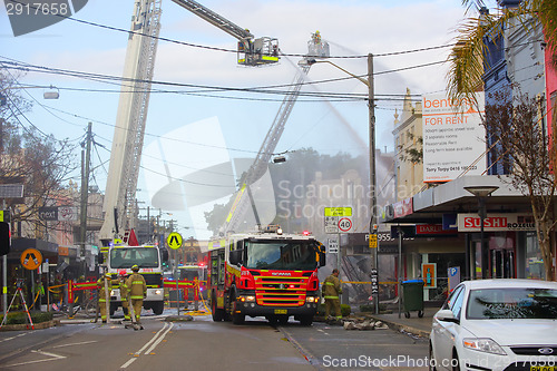 Image of Firemen douse flames after explosion at a convenience store in R