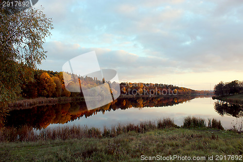 Image of landscape with river and forest reflecting in it