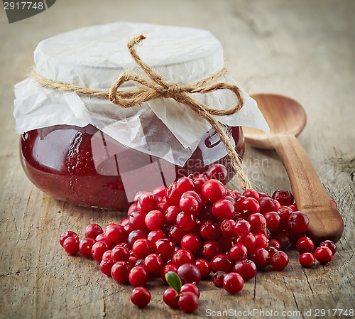 Image of fresh raw cowberries and jar of jam
