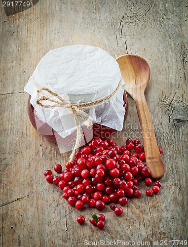 Image of fresh raw cowberries and jar of jam