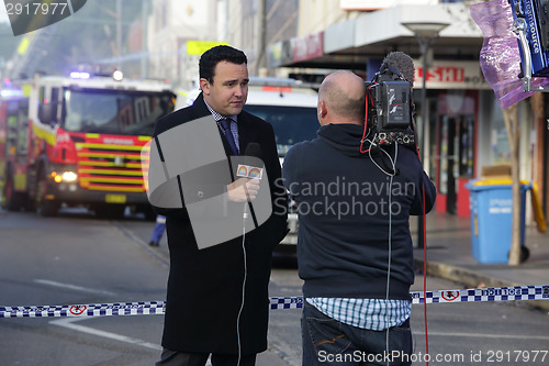 Image of News correspondent delivers a news bulletin on site of shop blas