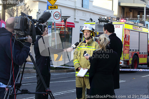 Image of TV News Crews briefed by Fire Superintendant.