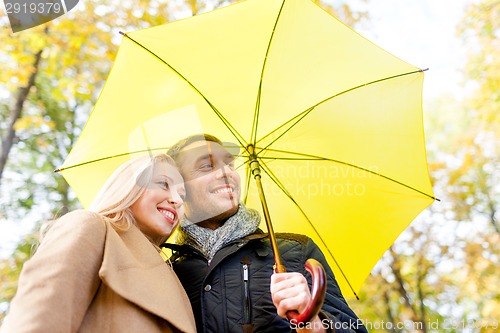 Image of smiling couple hugging in autumn park