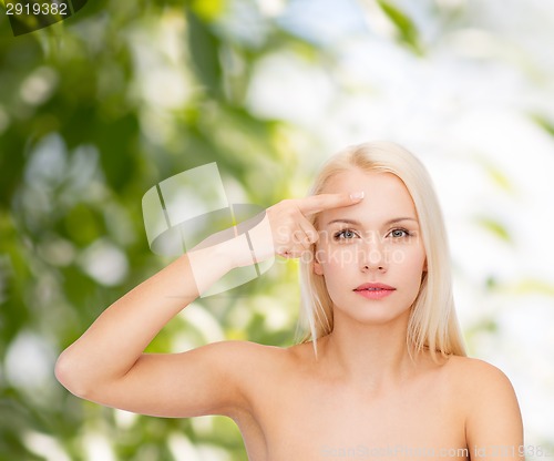 Image of beautiful woman touching her forehead