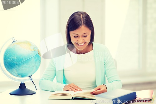 Image of teacher with globe and book at school