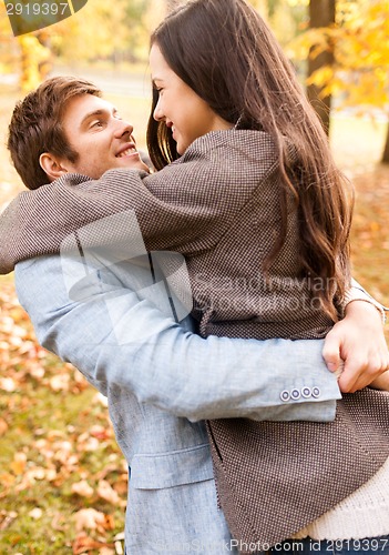 Image of smiling couple hugging in autumn park