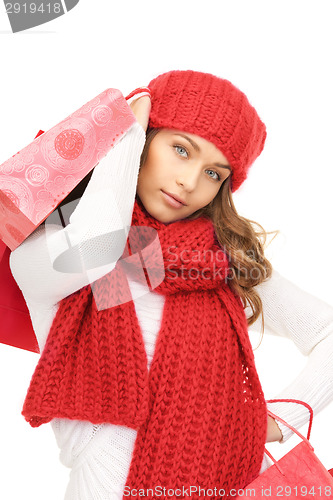 Image of smiling woman in winter clothes with shopping bags