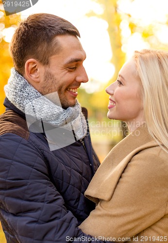 Image of smiling couple hugging in autumn park