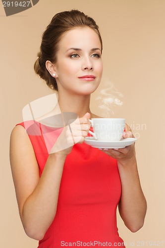 Image of smiling woman in red dress with cup of coffee