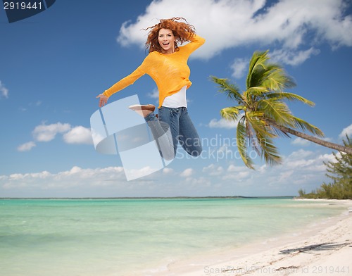 Image of smiling young woman jumping in air