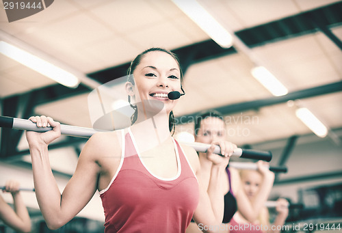 Image of group of smiling people working out with barbells
