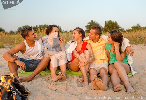 Image of smiling friends in sunglasses on summer beach