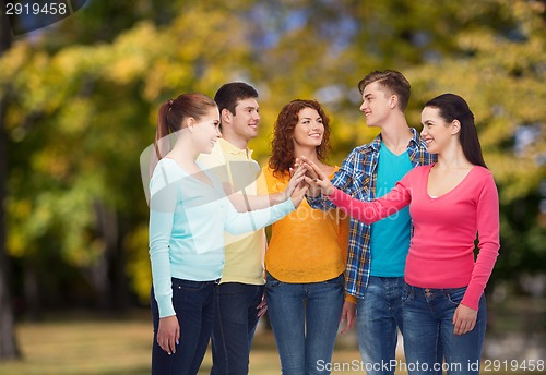 Image of group of smiling teenagers over green park