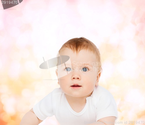 Image of smiling baby lying on floor and looking up