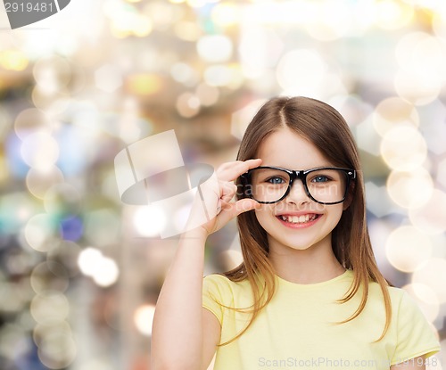 Image of smiling cute little girl in black eyeglasses