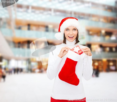 Image of woman in santa hat with gift box and stocking