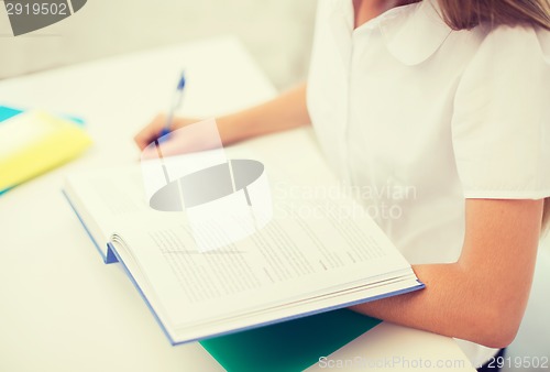 Image of student girl writing in notebook at school