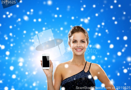 Image of smiling woman in evening dress holding smartphone