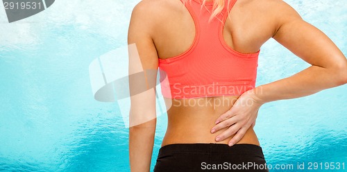 Image of close up of sporty woman touching her back