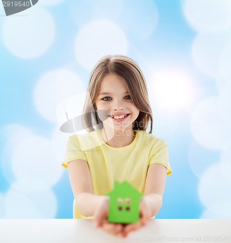 Image of beautiful little girl holding paper house cutout