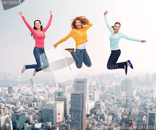 Image of group of smiling women jumping in air