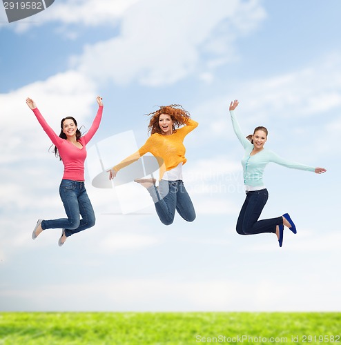 Image of group of smiling young women jumping in air