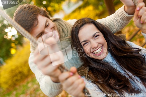 Image of smiling couple hugging in autumn park