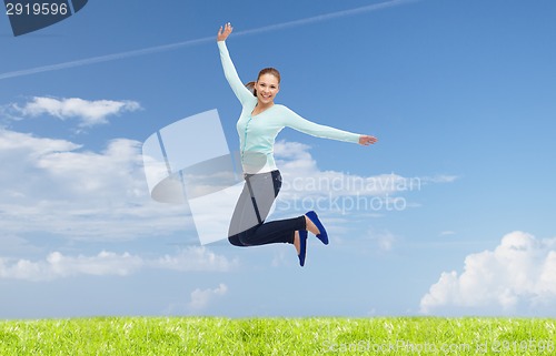 Image of smiling young woman jumping in air