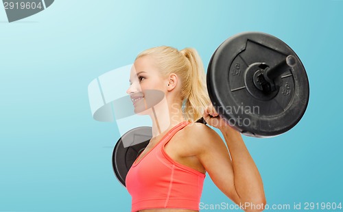 Image of smiling sporty woman exercising with barbell