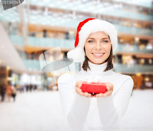 Image of smiling woman in santa helper hat with gift box