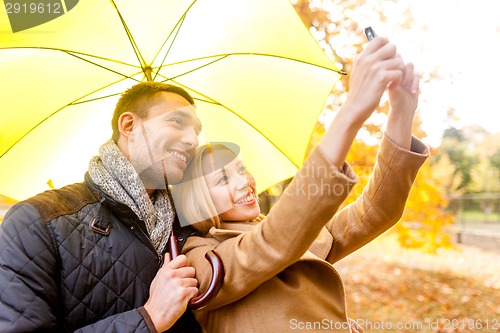 Image of smiling couple hugging in autumn park