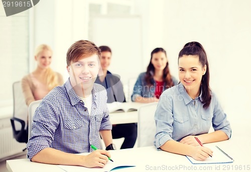 Image of smiling students with notebooks at school