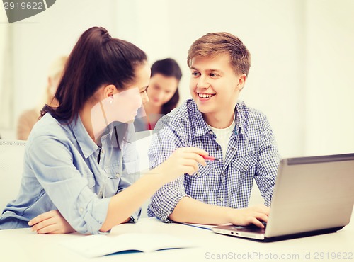 Image of two smiling students with laptop computer