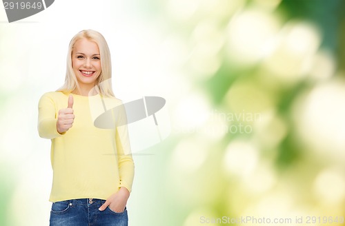 Image of smiling girl in casual clothes showing thumbs up