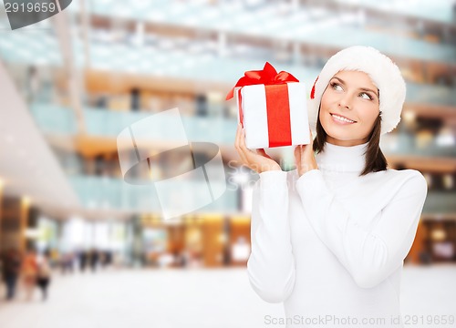 Image of smiling woman in santa helper hat with gift box
