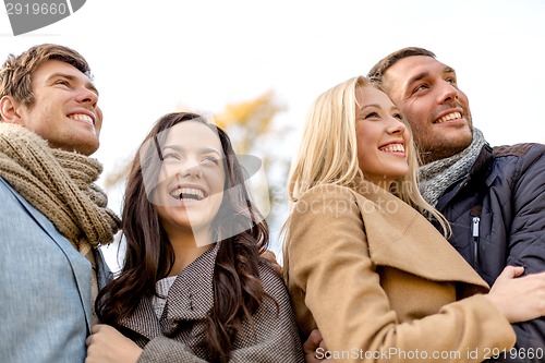 Image of group of smiling men and women in autumn park