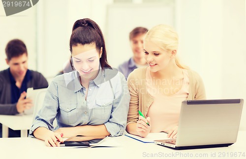 Image of two smiling students with laptop and tablet pc