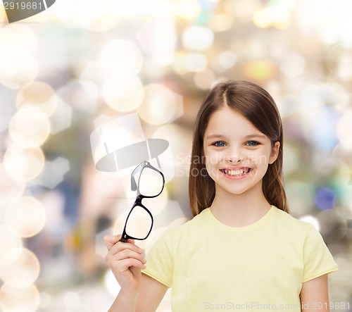 Image of smiling cute little girl holding black eyeglasses