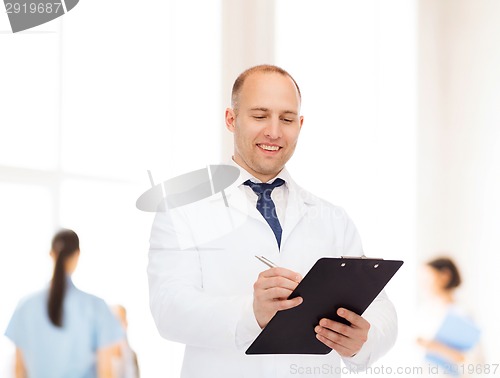 Image of smiling male doctor with clipboard